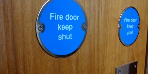 Closeup of fire door with blue keep shut sign