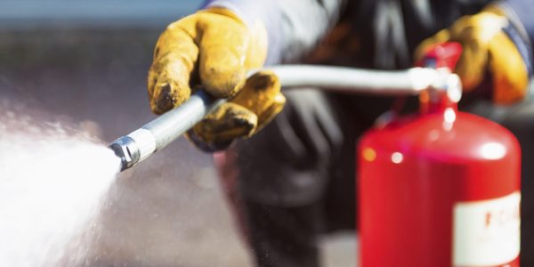 Closeup of fire warden using foam fire extinguisher